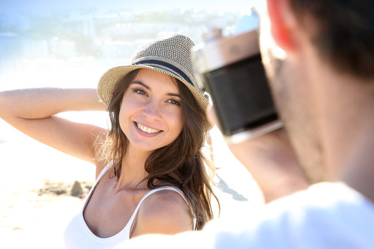 Man taking picture of beautiful woman at the beach