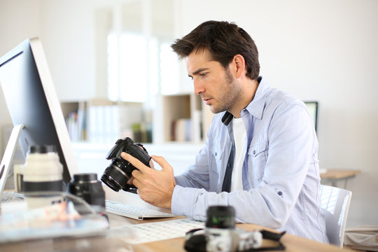 Photographer in office working on desktop computer