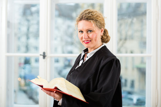 Anwältin in Kanzlei mit Gesetzbuch