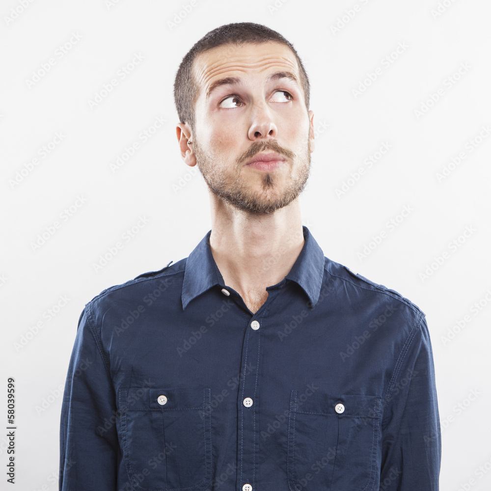 Wall mural closeup of young man looking up thinking on white background