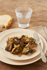 Dish of sauteed artichokes and yellow foot mushrooms