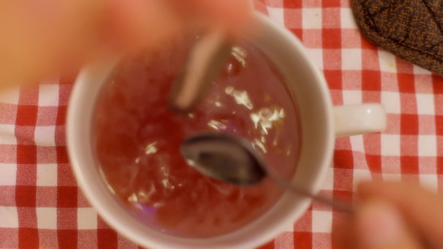 Tea cup from above shaking teaspoon