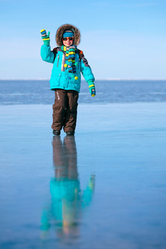 Cute little boy outdoors standing on frozen sea