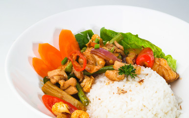 Chicken with rice and vegetables in background