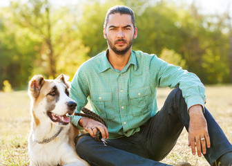 Man and central Asian shepherd walk in the park. 