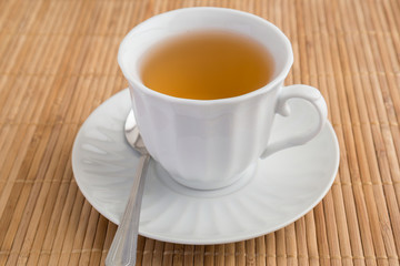 A cup of green tea on bamboo mat