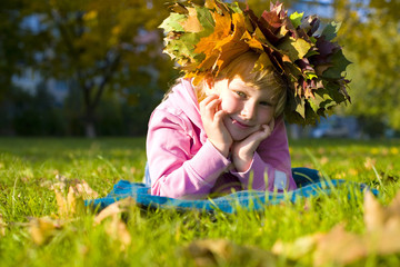 Portrait of the beautiful six-year-old girl in a wreath from aut