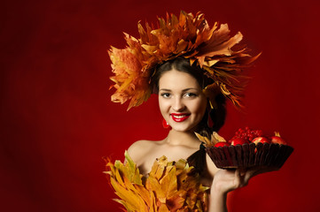 Fototapeta premium beautiful girl in wreath of yellow leaves with basket of fruit