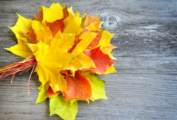 Bouquet of autumn leaves over old wooden background