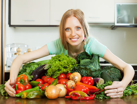 Portrait of woman with heap of vegetables