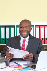 African business man with letter looking at camera