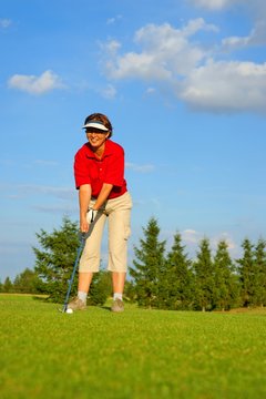 Golf, woman golfer  is going to punch the ball