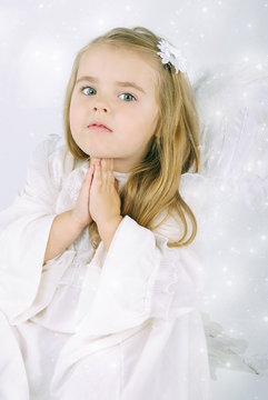 A beautiful little girl angel with a book