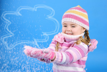 the little girl in a sweater and a hat with the snow