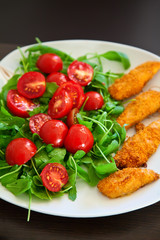 chicken nuggets served with ruccola and cherry tomato