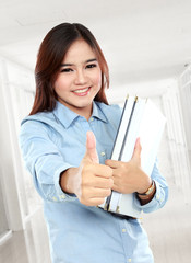 Happy student holding a few books and thumbs up