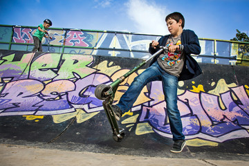 Enfants jouant au skate-park (trottinette)