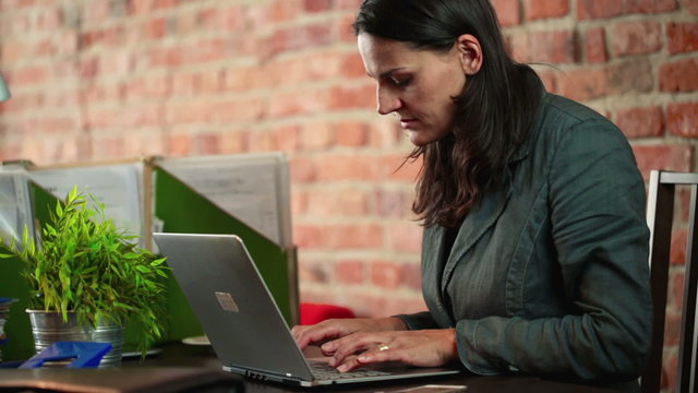 businesswoman typing quickly on her laptop