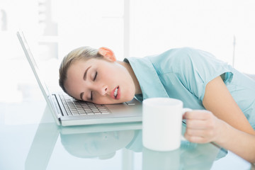 Young exhausted businesswoman sleeping sitting on her swivel cha