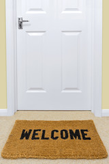 Welcome doormat outside a door.