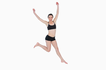 Obraz premium Full length of a sporty young woman jumping
