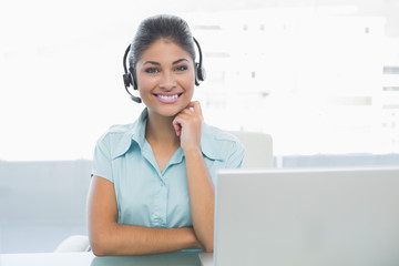 Businesswoman wearing headset in front of laptop