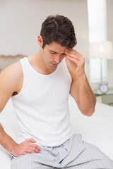 Man suffering from headache in bed
