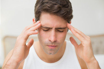 Fototapeta premium Close up of man suffering from headache in bed