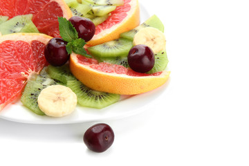 Assortment of sliced fruits on plate, isolated on white