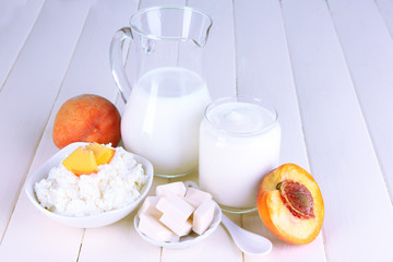 Fresh dairy products with peaches on wooden table close-up