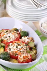 Stuffed tomatoes in bowl on wooden table close-up