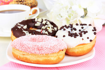 Sweet donuts with cup of tea on table close-up