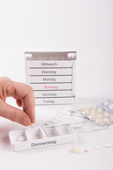 Tabletten in Medikamentenbox mit der Hand einfüllen
