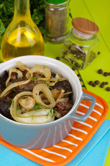 Fried chicken livers in pan on wooden table close-up