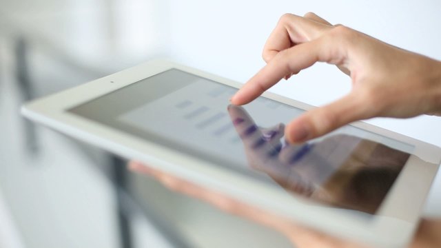 Closeup of woman's hand sliding on tablet screen