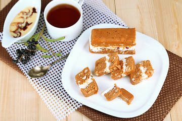 Tasty sherbet with nuts on plate on wooden table close-up