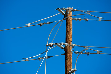 Detailed image of power lines and connections on a wooden post