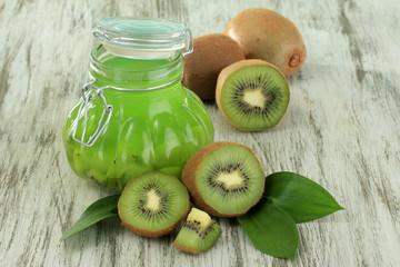 Jar of jam kiwi on wooden table close-up