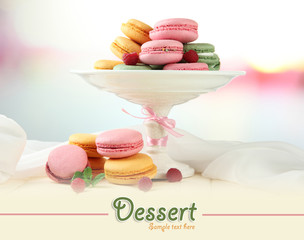 Gentle macaroons in vase on table on light background