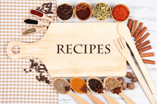 Various spices and herbs with empty wooden board
