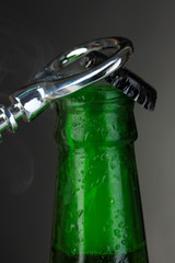 Top of open wet beer bottle on dark background