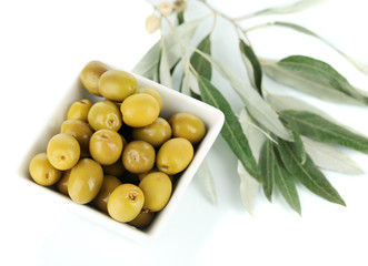 Olives in bowl with branch isolated on white