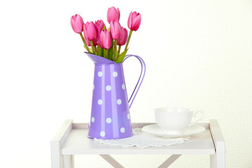 Flowers on white shelf on grey wall background