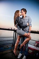 Handsome man and sexy woman hugging passionately on embankment