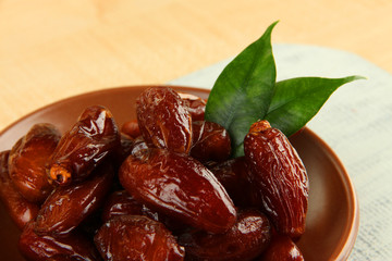 Dried dates on plate on wooden background