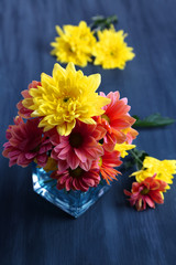 Chrysanthemum flowers in vase on wooden table close-up