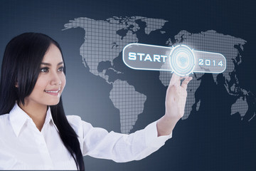 Businesswoman pressing a button of 2014