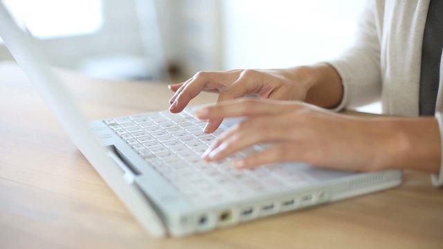 Woman's hand typing on laptop keyboard