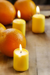 Fototapeta na wymiar Beautiful candles and juicy oranges on wooden table. Wonderful,