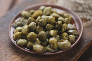 Ceramic plate with marinated capers, close-up